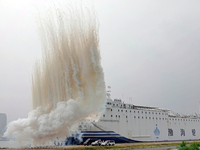 A national defense mobilization support team is camouflaging the ship's hull with smoke screens during a comprehensive defense mobilization...