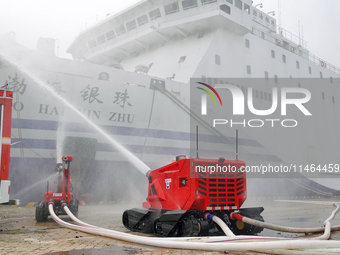 A fire-fighting robot is performing fire-fighting operations during a comprehensive defense mobilization drill in Yantai, China, on August 9...