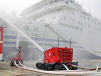 A fire-fighting robot is performing fire-fighting operations during a comprehensive defense mobilization drill in Yantai, China, on August 9...