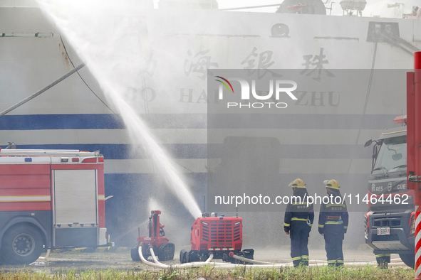 A fire-fighting robot is performing fire-fighting operations during a comprehensive defense mobilization drill in Yantai, China, on August 9...