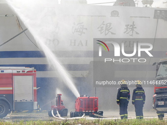 A fire-fighting robot is performing fire-fighting operations during a comprehensive defense mobilization drill in Yantai, China, on August 9...