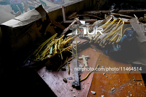 Crosses and wax candles are at the Church of the Nativity of the Blessed Virgin Mary, which is damaged by the Russian shelling on July 8, in...