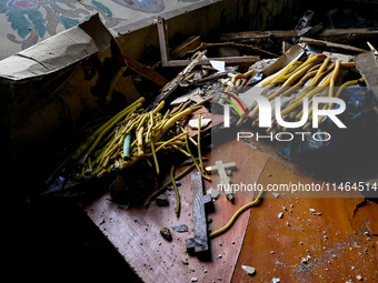 Crosses and wax candles are at the Church of the Nativity of the Blessed Virgin Mary, which is damaged by the Russian shelling on July 8, in...