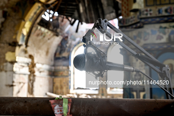 A microphone is at the Church of the Nativity of the Blessed Virgin Mary, damaged by the Russian shelling on July 8, in Novoekonomichne, Don...