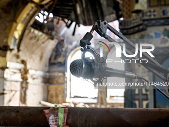 A microphone is at the Church of the Nativity of the Blessed Virgin Mary, damaged by the Russian shelling on July 8, in Novoekonomichne, Don...