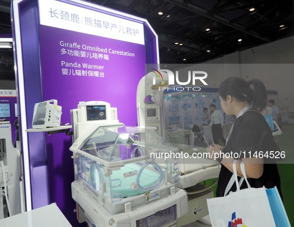 Visitors are visiting a ''multi-functional baby incubator'' at the 30th China International Medical Instruments and Equipment Exhibition in...