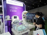 Visitors are visiting a ''multi-functional baby incubator'' at the 30th China International Medical Instruments and Equipment Exhibition in...