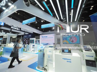 Visitors are viewing laser therapy equipment at the 30th China International Medical Instruments and Equipment Exhibition in Beijing, China,...