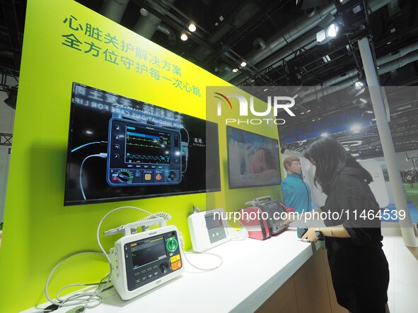 Visitors are experiencing a ''defibrillator'' at the 30th China International Medical Instruments and Equipment Exhibition in Beijing, China...