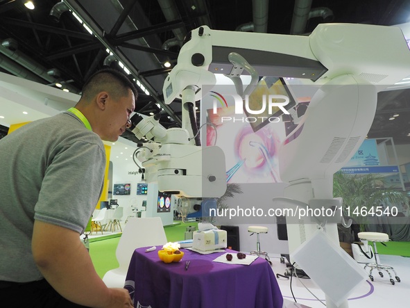 Visitors are viewing the ''Ophthalmic surgical microscope'' at the 30th China International Medical Instruments and Equipment Exhibition in...