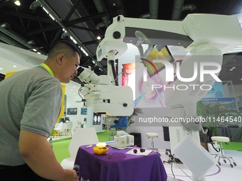 Visitors are viewing the ''Ophthalmic surgical microscope'' at the 30th China International Medical Instruments and Equipment Exhibition in...