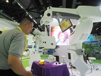 Visitors are viewing the ''Ophthalmic surgical microscope'' at the 30th China International Medical Instruments and Equipment Exhibition in...