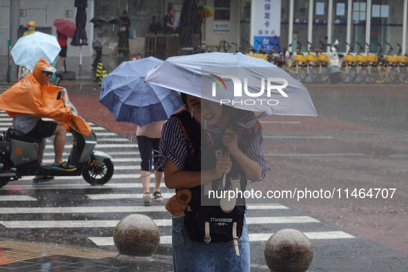 Pedestrians are walking during a rainstorm in Beijing, China, on August 9, 2024. 