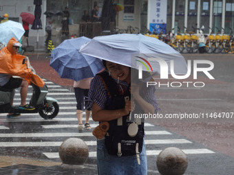 Pedestrians are walking during a rainstorm in Beijing, China, on August 9, 2024. (