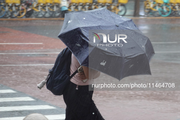 Pedestrians are walking during a rainstorm in Beijing, China, on August 9, 2024. 