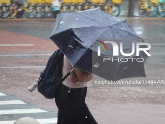 Pedestrians are walking during a rainstorm in Beijing, China, on August 9, 2024. (