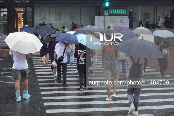 Pedestrians are walking during a rainstorm in Beijing, China, on August 9, 2024. 