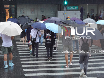 Pedestrians are walking during a rainstorm in Beijing, China, on August 9, 2024. (