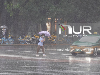 Pedestrians are walking during a rainstorm in Beijing, China, on August 9, 2024. (