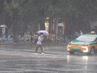 Pedestrians are walking during a rainstorm in Beijing, China, on August 9, 2024. (