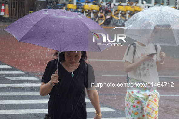 Pedestrians are walking during a rainstorm in Beijing, China, on August 9, 2024. 