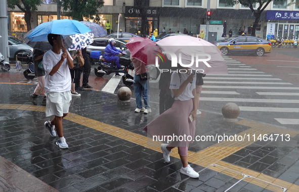 Pedestrians are walking during a rainstorm in Beijing, China, on August 9, 2024. 