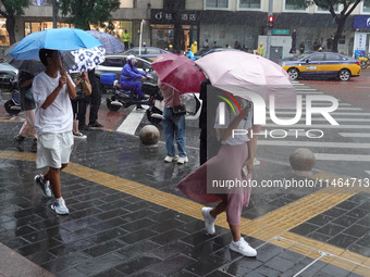 Pedestrians are walking during a rainstorm in Beijing, China, on August 9, 2024. (