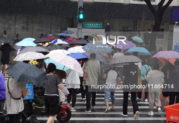 Pedestrians are walking during a rainstorm in Beijing, China, on August 9, 2024. 