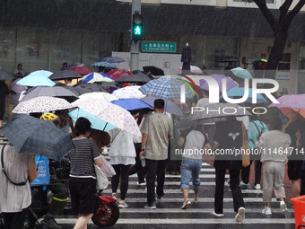 Pedestrians are walking during a rainstorm in Beijing, China, on August 9, 2024. (