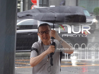 Pedestrians are walking during a rainstorm in Beijing, China, on August 9, 2024. (