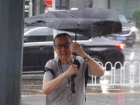 Pedestrians are walking during a rainstorm in Beijing, China, on August 9, 2024. (