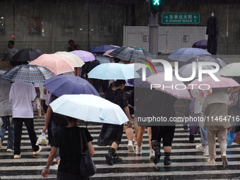 Pedestrians are walking during a rainstorm in Beijing, China, on August 9, 2024. (