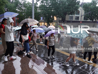 Pedestrians are walking during a rainstorm in Beijing, China, on August 9, 2024. (