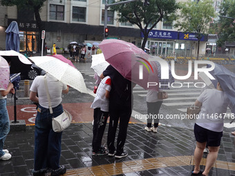 Pedestrians are walking during a rainstorm in Beijing, China, on August 9, 2024. (