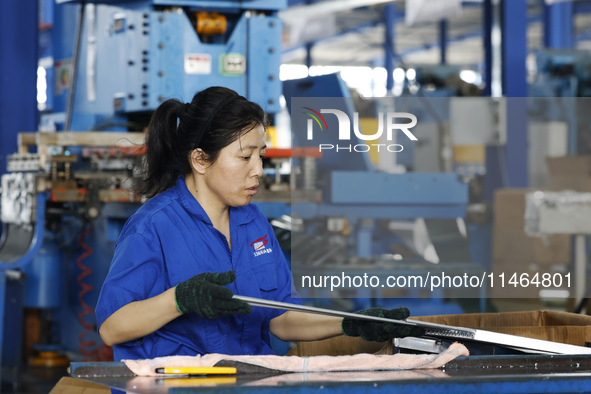 Workers are working at a production workshop of an auto parts company in Suqian, Jiangsu province, China, on August 9, 2024. 