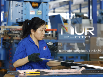 Workers are working at a production workshop of an auto parts company in Suqian, Jiangsu province, China, on August 9, 2024. (