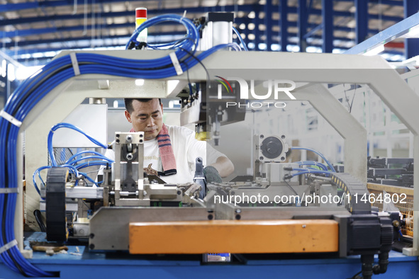 Workers are working at a production workshop of an auto parts company in Suqian, Jiangsu province, China, on August 9, 2024. 