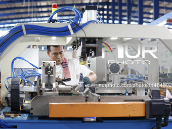 Workers are working at a production workshop of an auto parts company in Suqian, Jiangsu province, China, on August 9, 2024. (