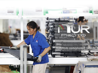 Workers are working at a production workshop of an auto parts company in Suqian, Jiangsu province, China, on August 9, 2024. (