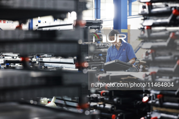 Workers are working at a production workshop of an auto parts company in Suqian, Jiangsu province, China, on August 9, 2024. 