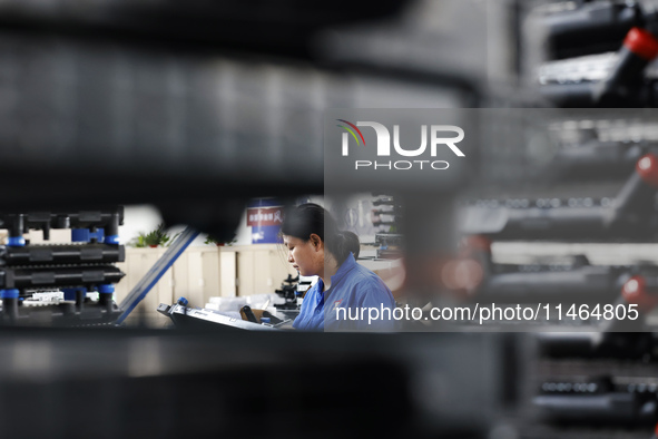 Workers are working at a production workshop of an auto parts company in Suqian, Jiangsu province, China, on August 9, 2024. 