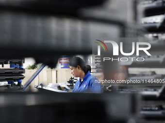 Workers are working at a production workshop of an auto parts company in Suqian, Jiangsu province, China, on August 9, 2024. (