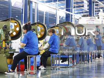 Workers are working at a production workshop of an auto parts company in Suqian, Jiangsu province, China, on August 9, 2024. (