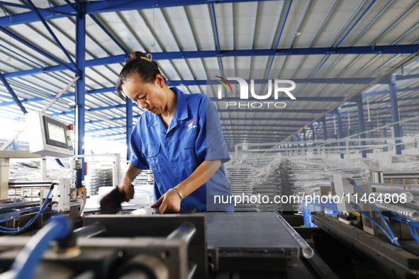 Workers are working at a production workshop of an auto parts company in Suqian, Jiangsu province, China, on August 9, 2024. 