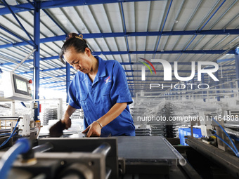 Workers are working at a production workshop of an auto parts company in Suqian, Jiangsu province, China, on August 9, 2024. (