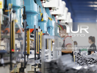 Workers are working at a production workshop of an auto parts company in Suqian, Jiangsu province, China, on August 9, 2024. (