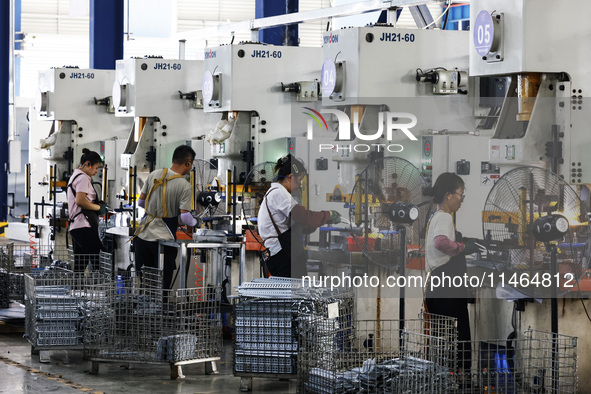 Workers are working at a production workshop of an auto parts company in Suqian, Jiangsu province, China, on August 9, 2024. 