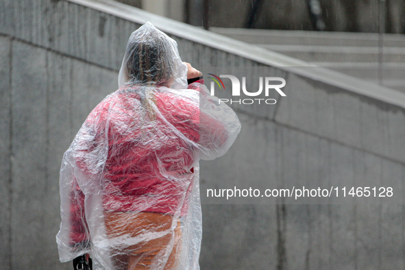 Pedestrians are protecting themselves from the rain in the central region of Sao Paulo, Brazil, on Friday, August 9. 