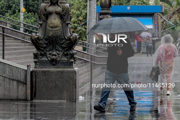 Pedestrians are protecting themselves from the rain in the central region of Sao Paulo, Brazil, on Friday, August 9. 