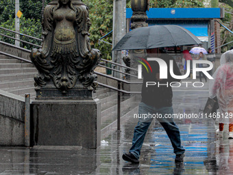 Pedestrians are protecting themselves from the rain in the central region of Sao Paulo, Brazil, on Friday, August 9. (